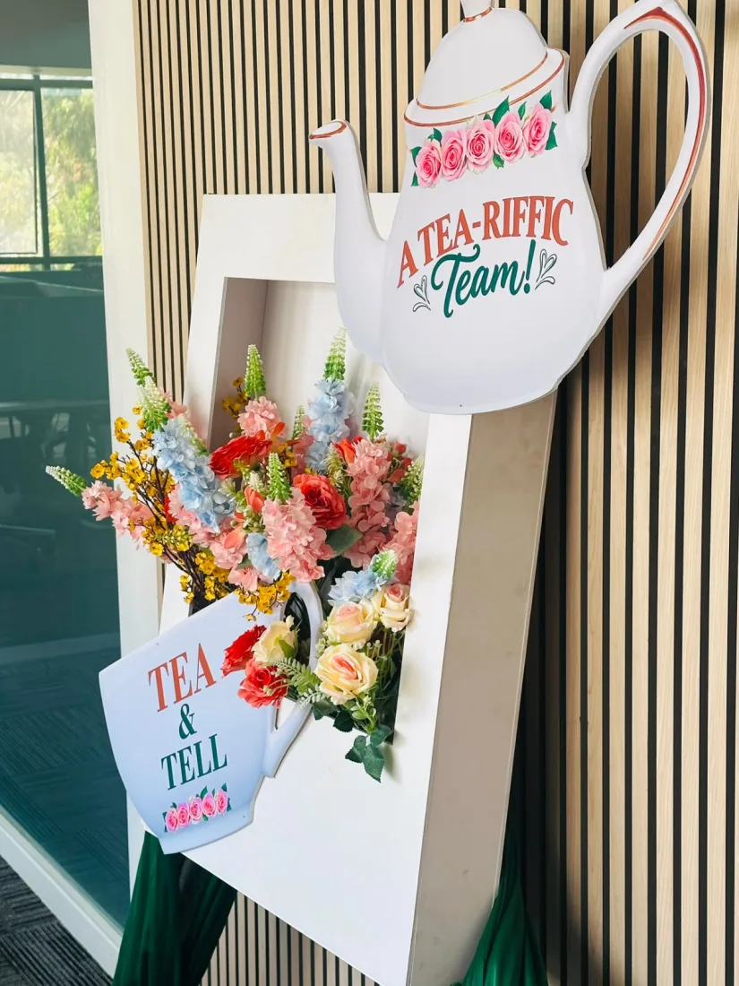 A hand-built teapot and teacup standee reading A Tea-riffic Team and Tea and Tell, decorated with pastel silk florals